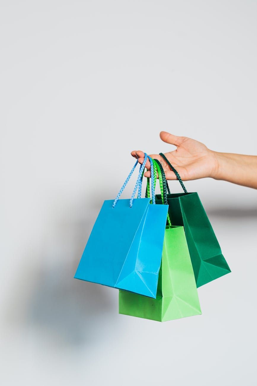A brown paper grocery bag overflows with fresh vegetables, fruit, milk, and bread.