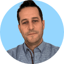 Professional headshot of a man with dark hair and light blue shirt, looking forward.