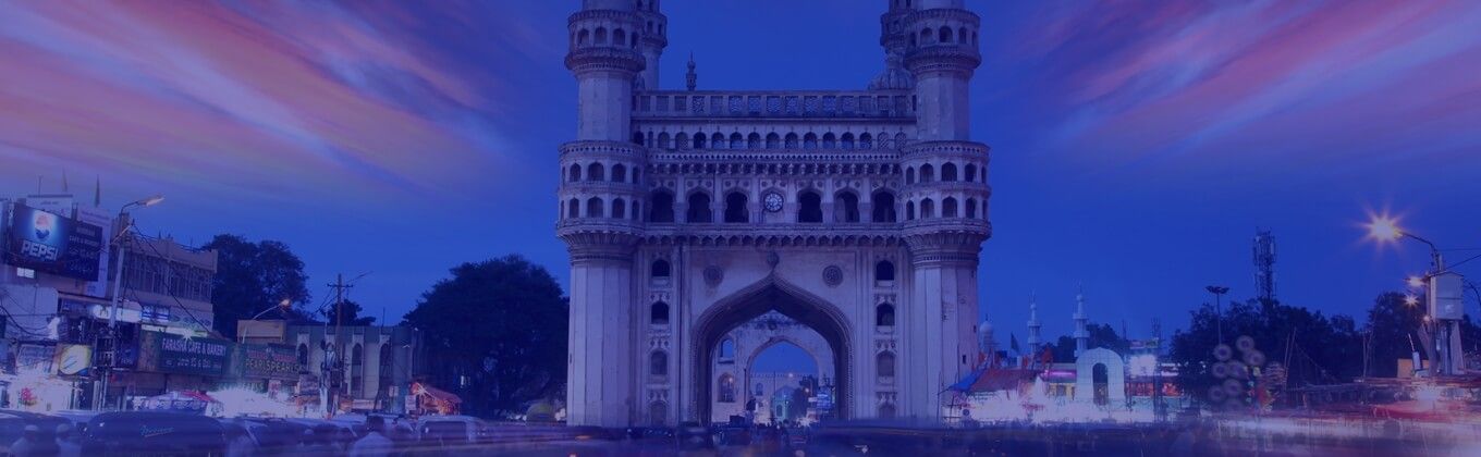 The Charminar monument in Hyderabad, India, at dusk with light trails.
