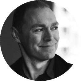 Black and white headshot of a smiling man looking subtly to his right.