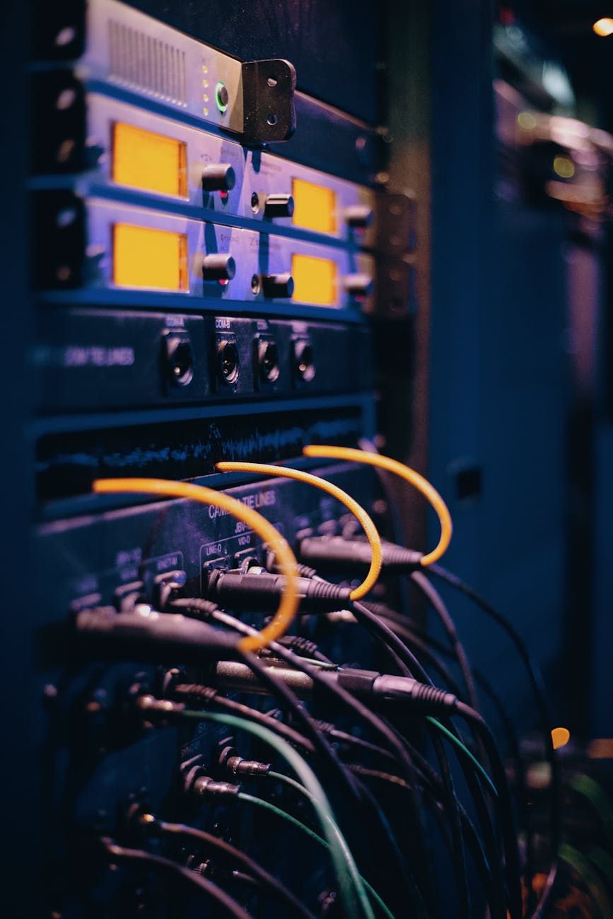 Server racks with numerous network cables plugged in, showing glowing indicator lights.